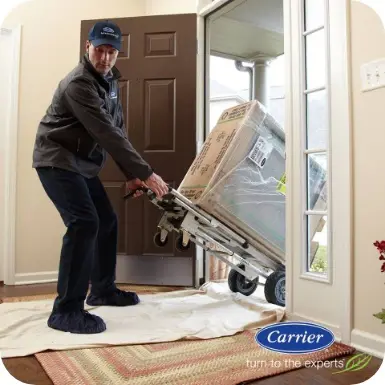 Worker bringing in a Carrier AC unit